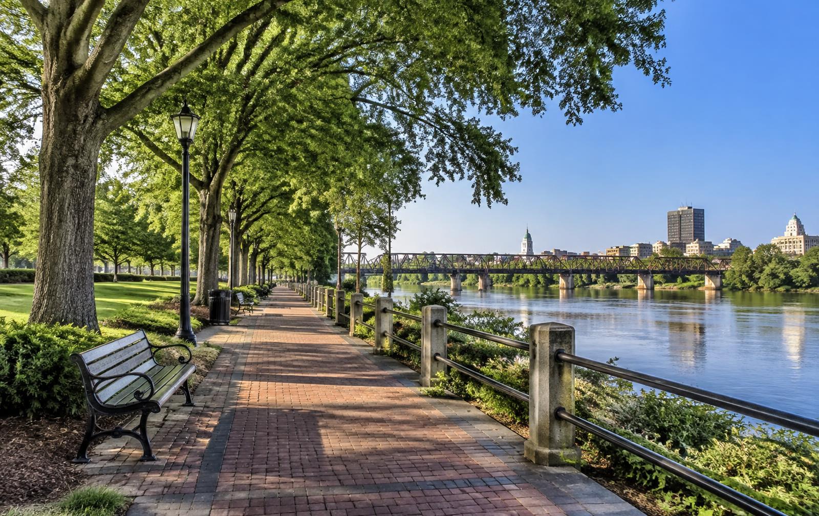 Augusta Riverwalk brick path and shade trees along the Savannah River in Augusta, Georgia on a bright morning